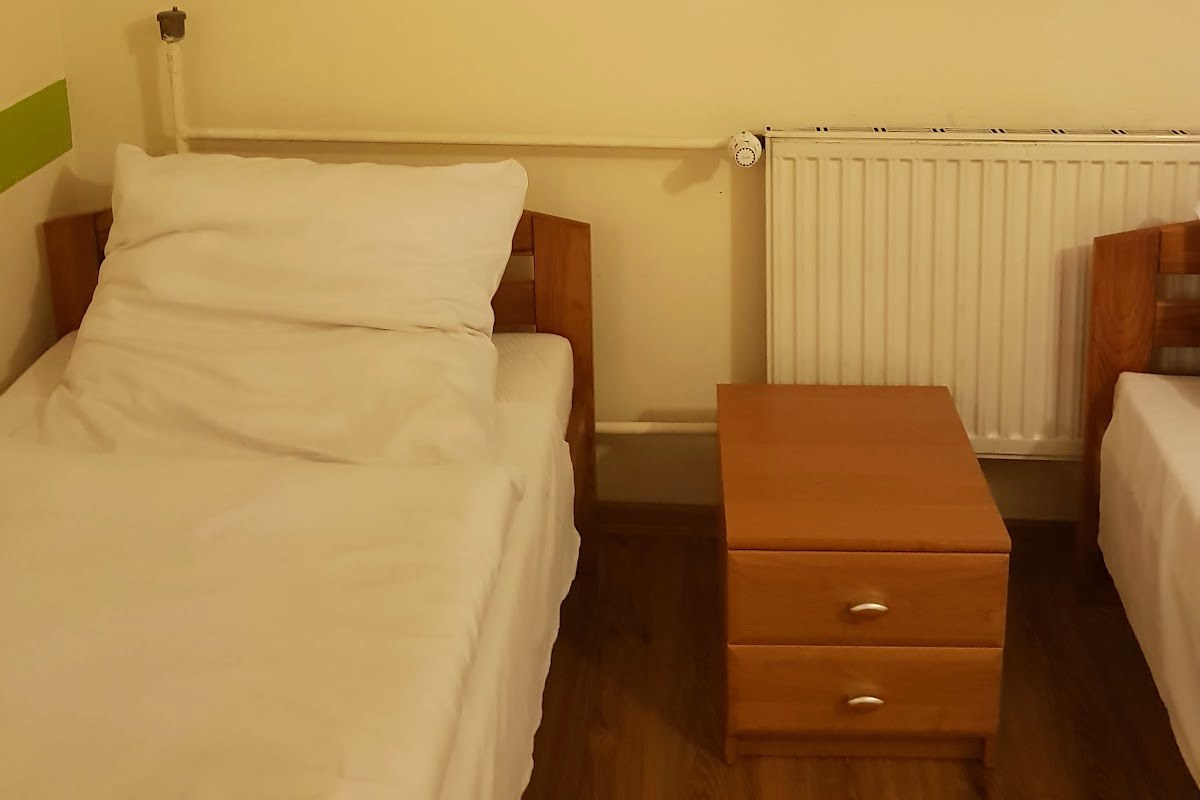 Pokój dwuosobowy w motelu ES, dwa łóżka i szafka nocna